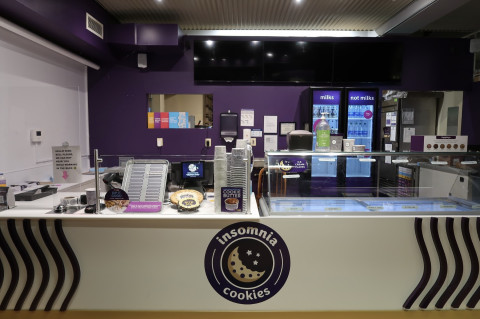 Table, Desk, Shop, Indoors. Text: milks not milks toppings HELLO! RING WE CAN NOT HEAR YOU ICE CREAM WHILE WORKING FLAVAS IN THE BACK COOKIE BUTTER insomnia cookies