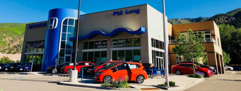 Car, Car Dealership, Vehicle, Building. Text: Phil Long HONDA AS LOW new AWD with our A S Honda Spec ials!