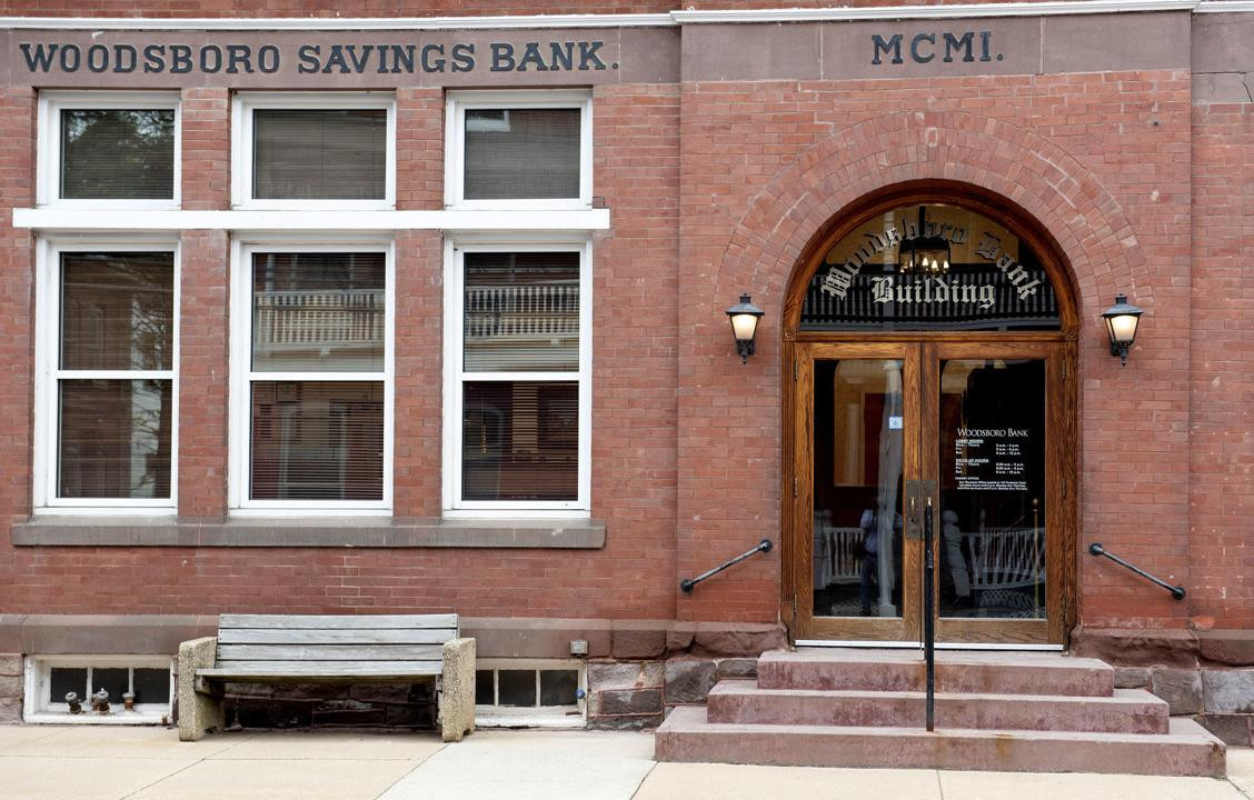 Bench, City, Brick, Building. Text: MCMI. WOODSBORO SAVINGS BANK. WOODSBORO BANK
