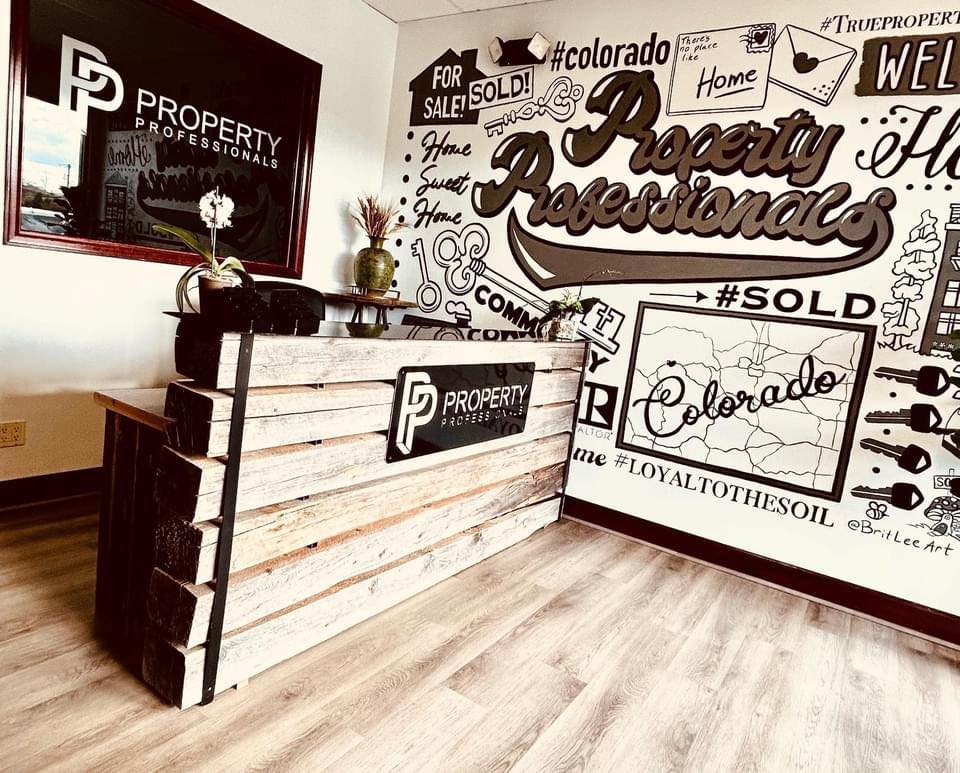 Indoors, Interior Design, Shop, Table. Text: #TRUEPROPERT PP There&#039;s #colorado like FOR WEL SOLD! SALE! Home PROPERTY PROFESSIONALS Home Sweet Home COMM #SOLD Y PROPERTY R ALTOR Colorado me #LOYALTOTHESOIL @BritLeeArt
